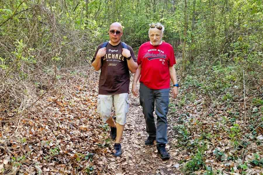 2 Männer spazieren durch den Wald und führen ein Gespräch